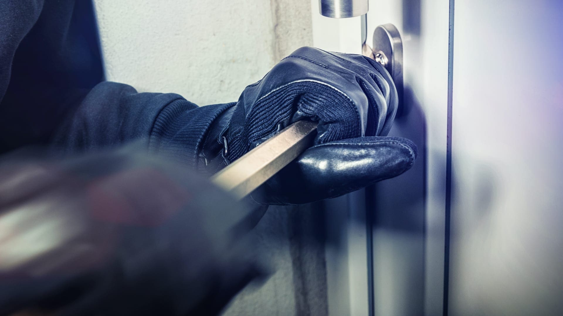 A burglar trying to open a lock used for preventing a burglary